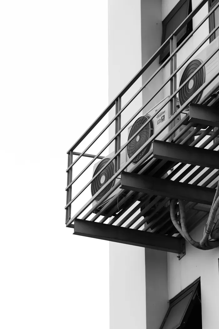 Outdoor air conditioning units mounted along a building balcony
